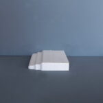 Houten plintprofiel tegen een blauwe achtergrond