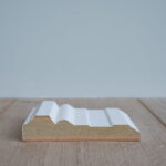 Houten plint dwarsdoorsnede op houten vloer.