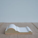 Profiel van witte plint op houten vloer