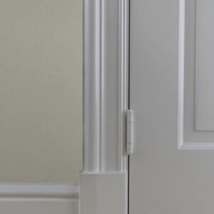 Witte deur met scharnier en plinten