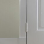 Witte deur met scharnier en beige muur