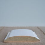 Witte plintprofiel op houten vloer