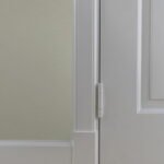 Witte deur met scharnier en lichte wand