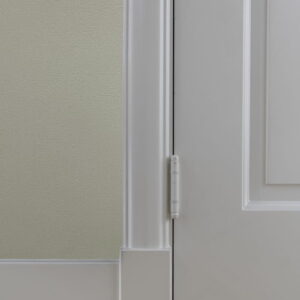 Detail van witte deur met scharnier op houten vloer
