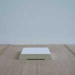 Houten vloer met witte plintprofiel.