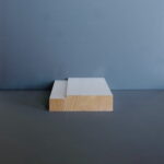 Stuk hout voor grijze achtergrond op tafel.