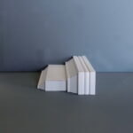 Houten plintprofiel tegen een blauwe achtergrond.