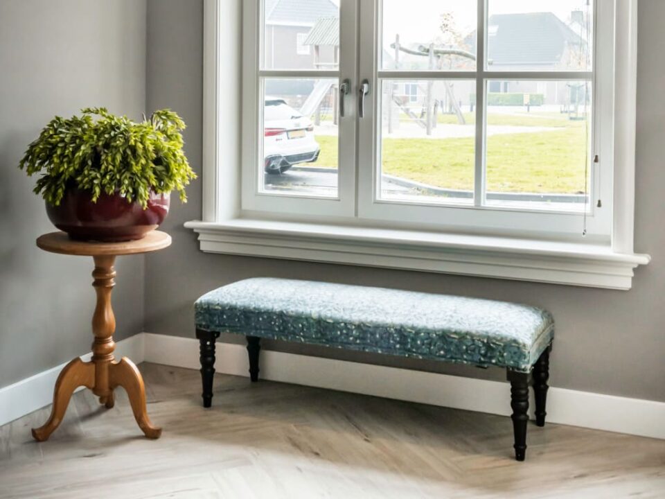 Bankje bij raam met plant op tafeltje