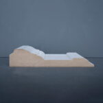 Houten profiel in zijaanzicht tegen grijze achtergrond.