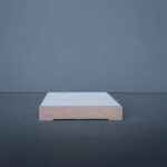 Close-up van grijze plank op donkere achtergrond.