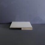 Vierkante grijze tegel op zwarte achtergrond.