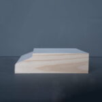 Profiel van een houten plank op een donkere achtergrond.