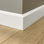 Witte plint langs hoek van houten vloer