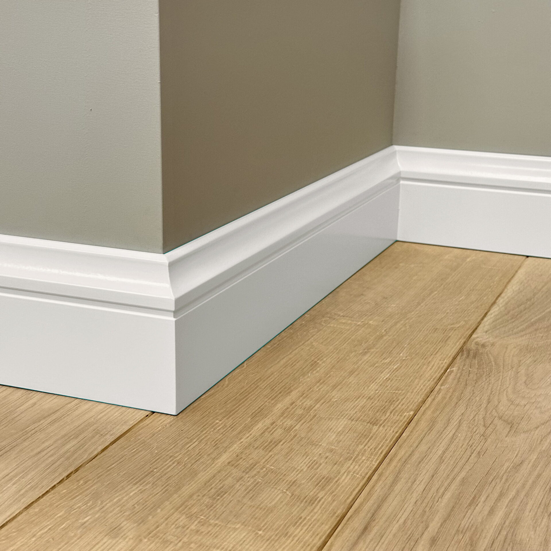 Plint en houten vloer in hoek van kamer.