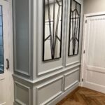 Moderne hal met spiegels en houten vloer.