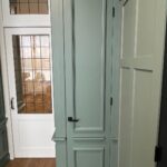 Groene deur in lichte hal met houten vloer