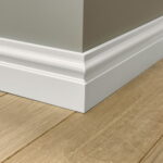 Witte plint langs houten vloer en muur