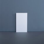 Leeg wit canvas tegen grijze muur.