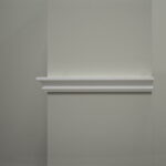 Grijze muur met witte decoratieve lijst