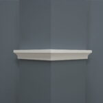 Witte wandplank in hoek tegen grijze muur
