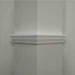 Hoek van een grijze muur met witte kroonlijst