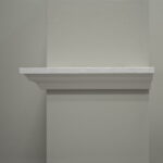 Lege witte muurplank tegen grijze achtergrond.