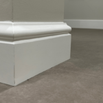 Witte plint op grijze vloer in interieur