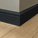 Zwarte plint op hoek van houten vloer