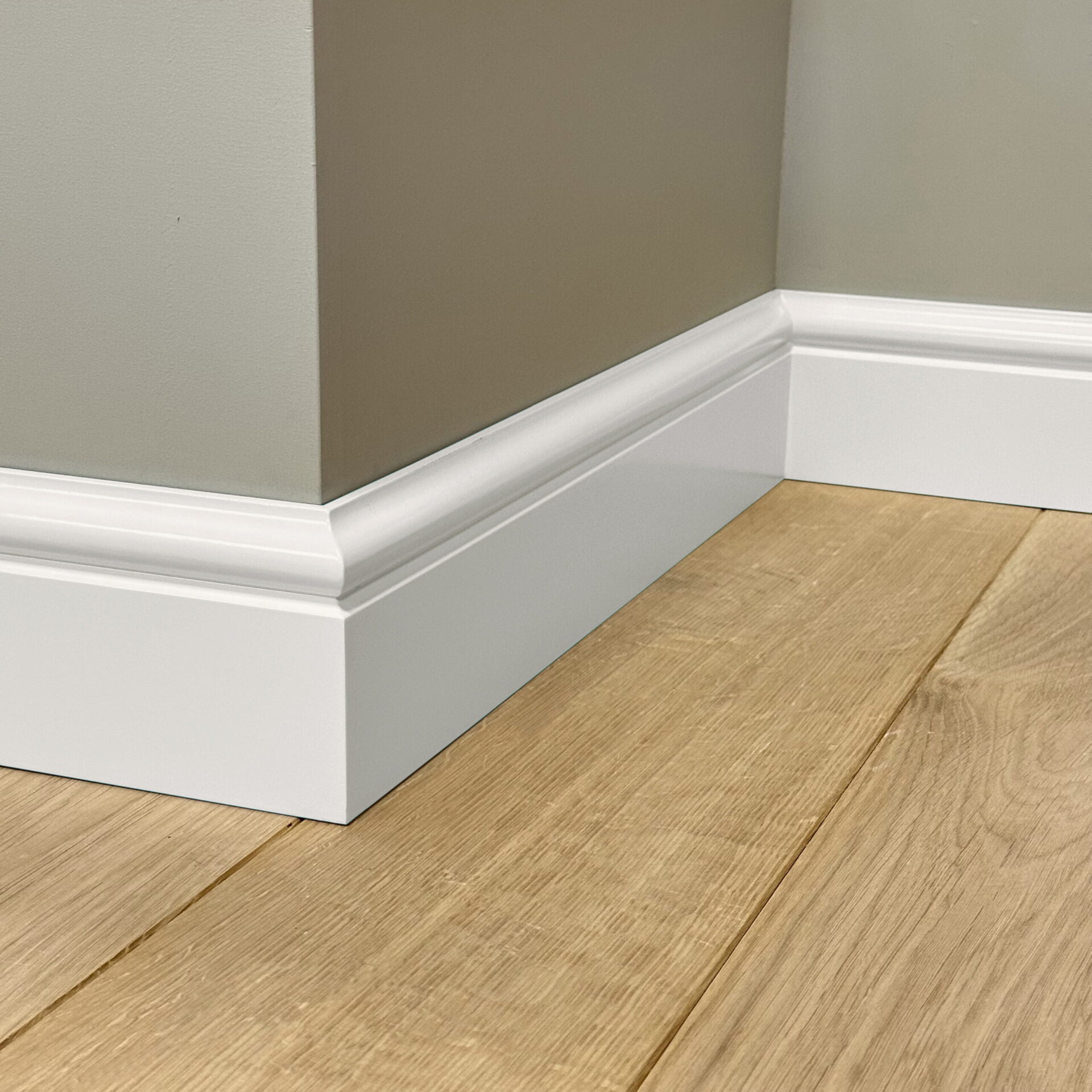 Witte plint langs houten vloer in hoek kamer
