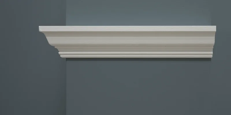 Witte MDF sierlijst met klassiek profiel tegen een blauwgrijs geschilderde muur