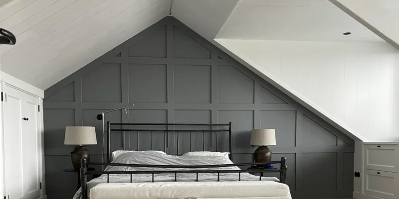 Hoge wand met grijze lambrisering in vakverdeling boven een slaapkamer, een stijlvol voorbeeld voor trapgat ideeën