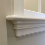 Witte plint op muur met paneeldetail.