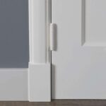 Witte deur met scharnier naast muur