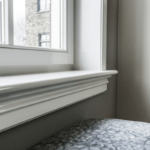 Wit kozijn met gordijnen en uitzicht op buitenmuur.