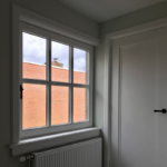 Binnenuitzicht met raam en bakstenen muur.