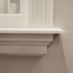 Detail van wit geschilderde houten sierlijst muur